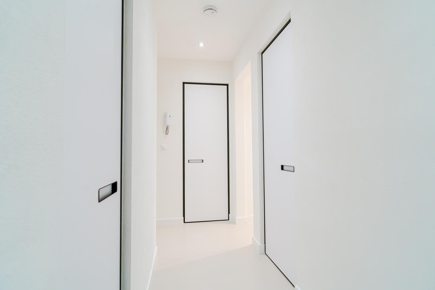 Strakke vlakke taatsdeuren in minimalistisch interieur