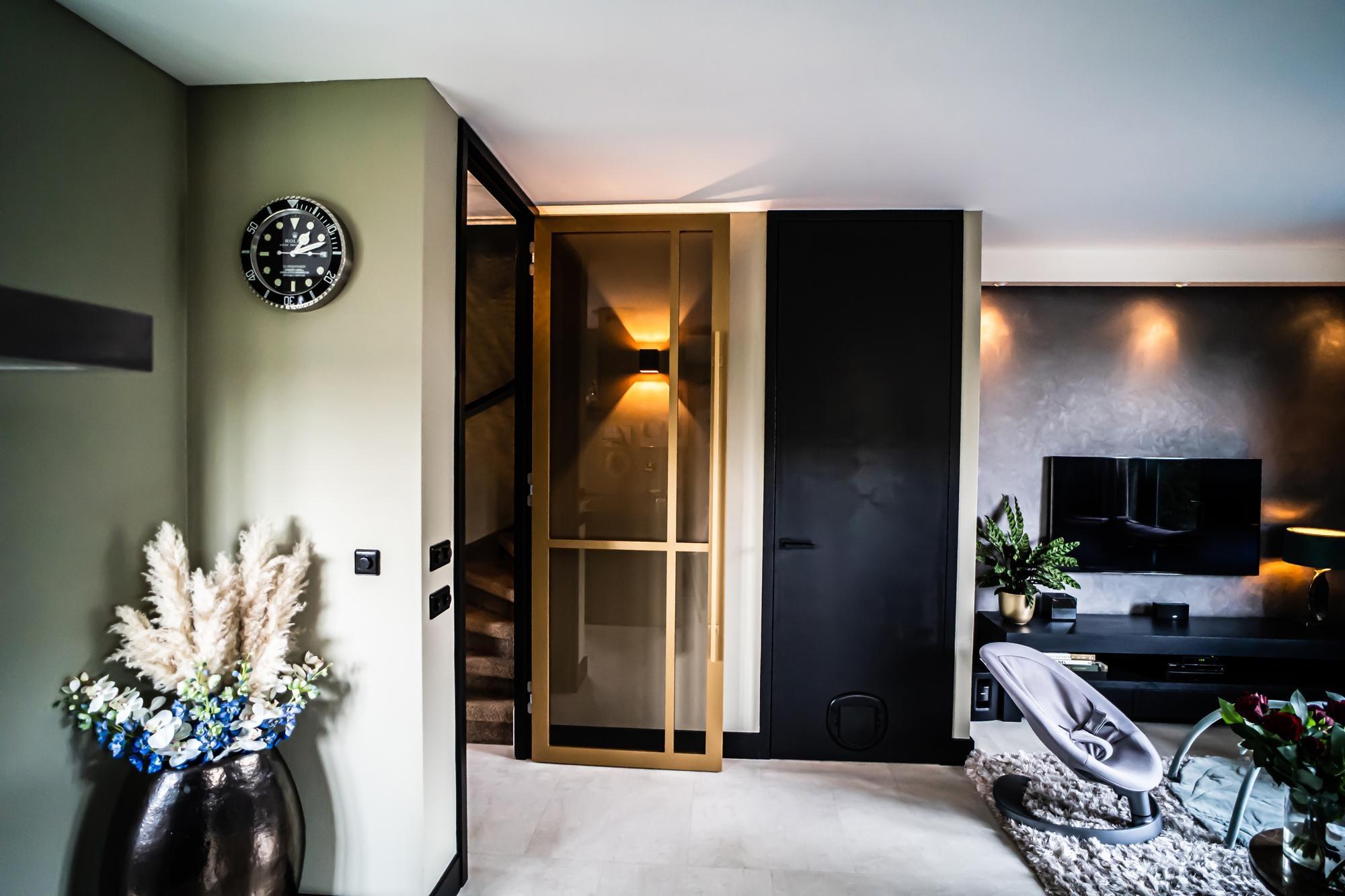 Modern chique interieur met gouden plafondhoge deur